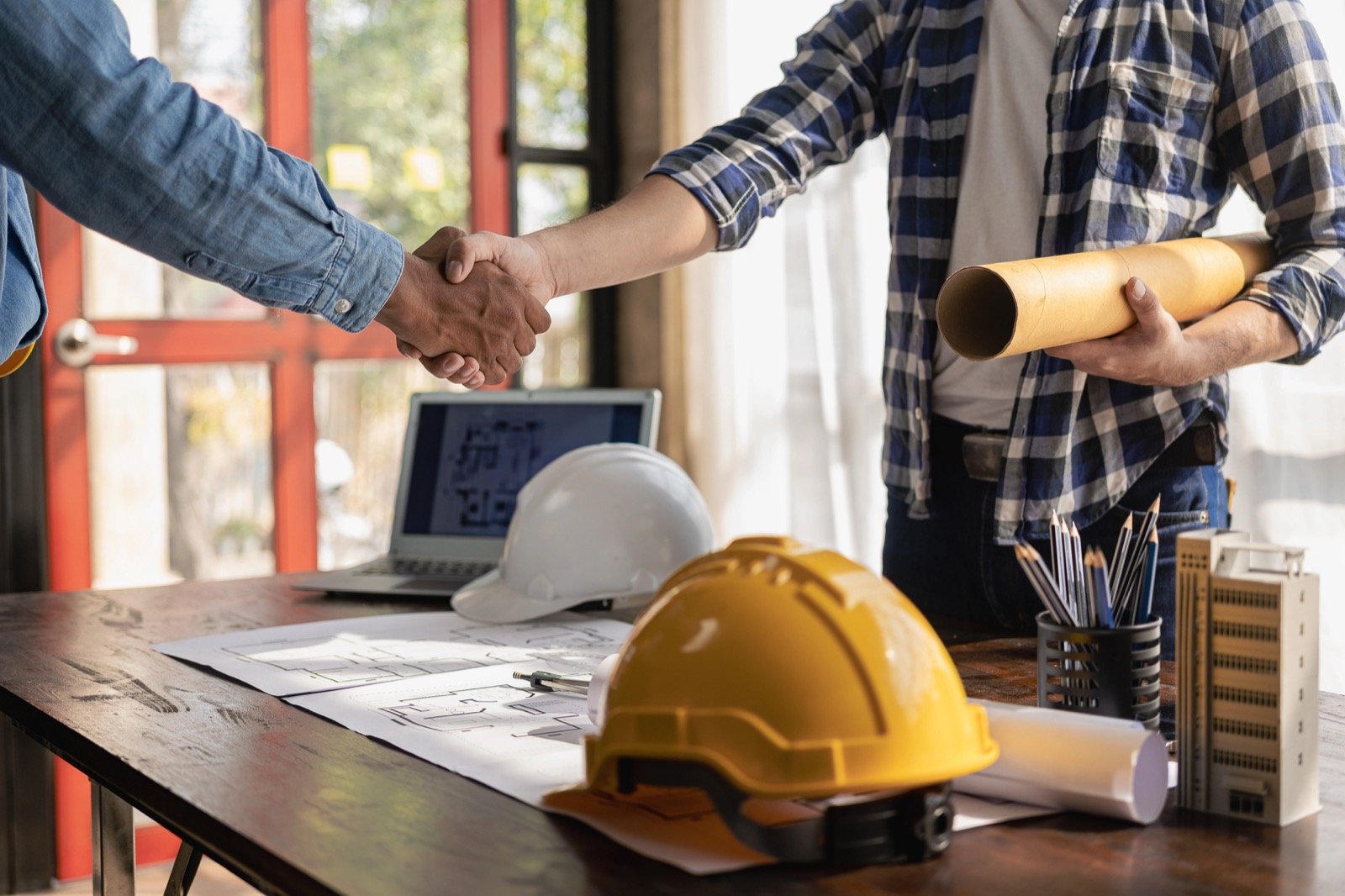 Contractor and crew reviewing blueprints at a residential construction site