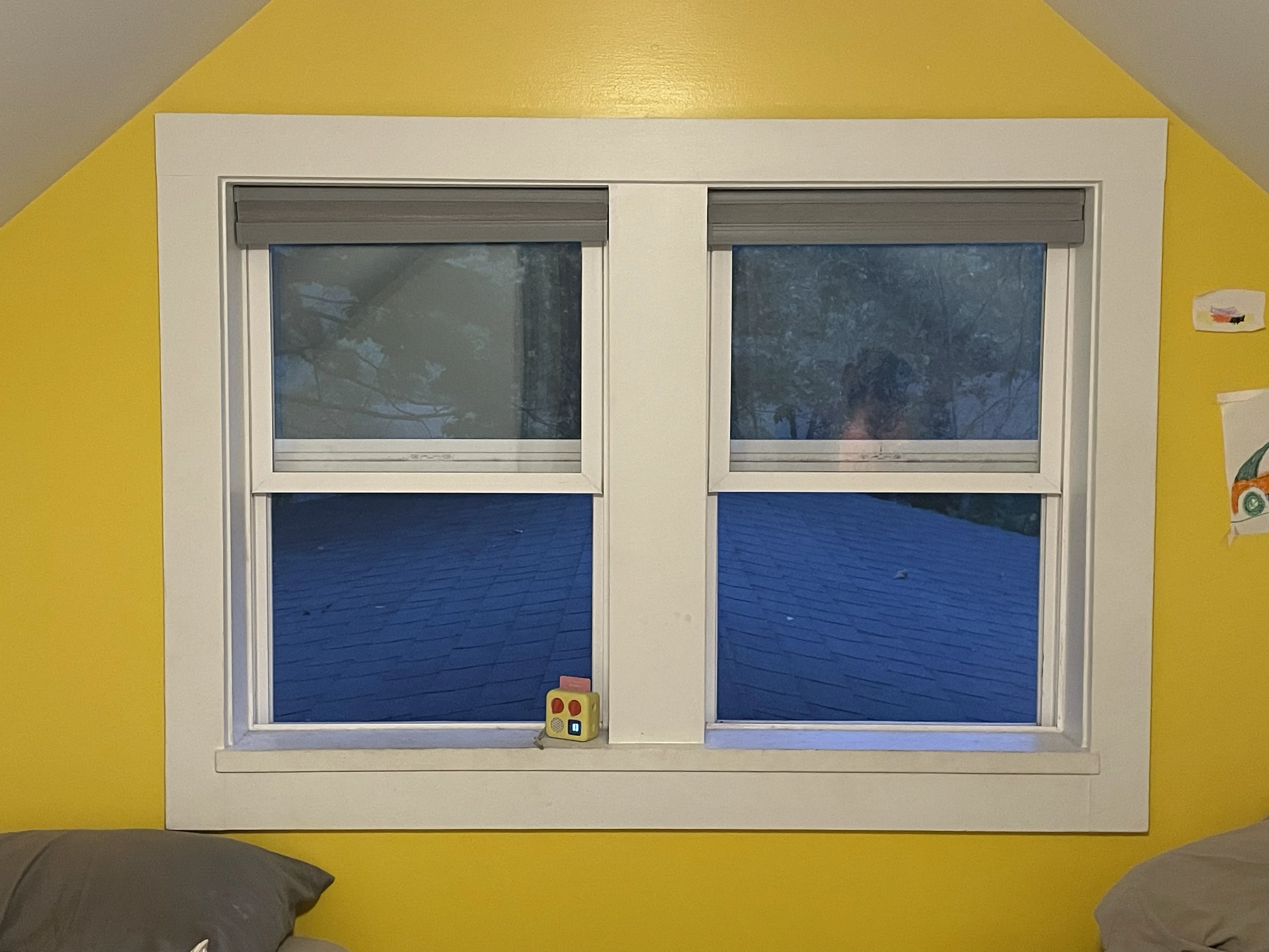 Double-hung windows installed in bedroom with yellow wall